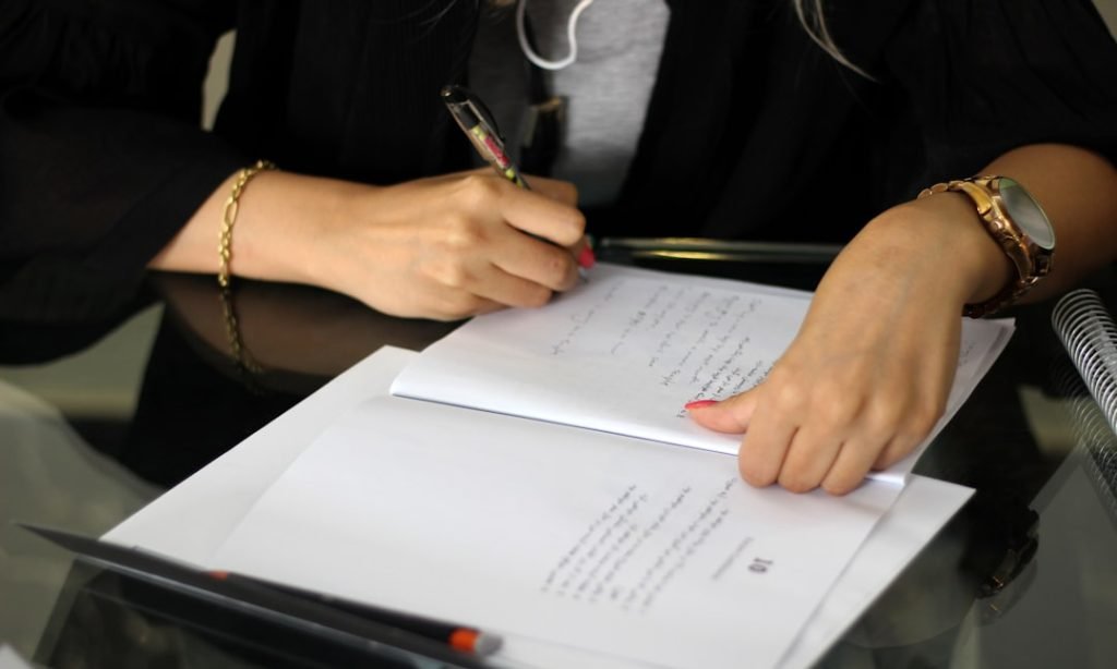 a-person-writing-on-a-piece-of-paper-cugr2cyqzec